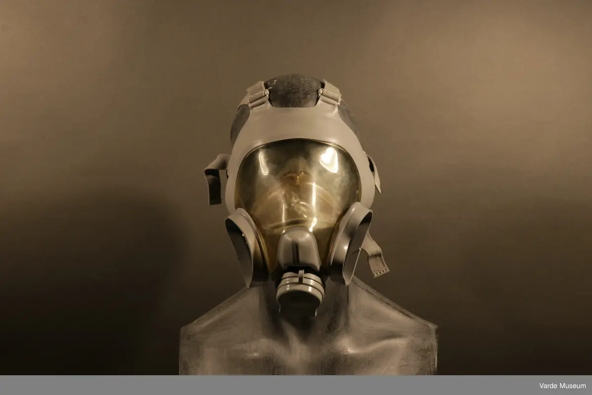 Sivilforsvaret gassmaske komplett med gass- og støvfilter. Masken er en ansiktsmaske med et stor synsfelt. Masken har seks festereimer og et samle-punkt .Gassmasken har to rektangulær festepunkt til gass og støvfilteret patroner.