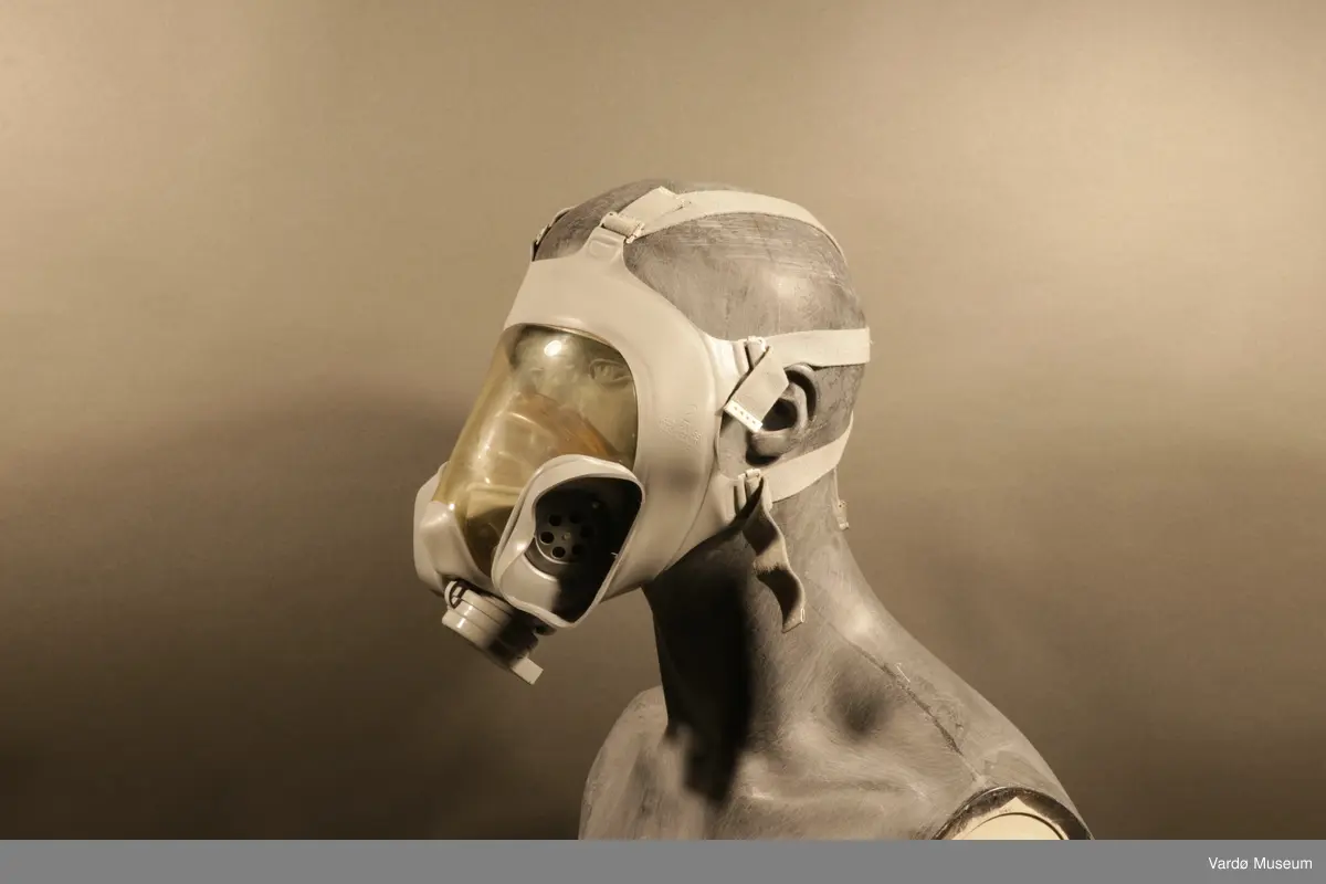 Sivilforsvaret gassmaske komplett med gass- og støvfilter. Masken er en ansiktsmaske med et stor synsfelt. Masken har seks festereimer og et samle-punkt .Gassmasken har to rektangulær festepunkt til gass og støvfilteret patroner.