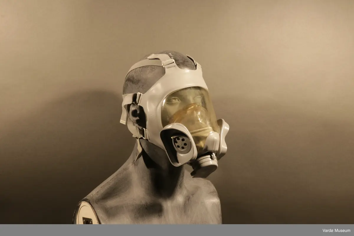 Sivilforsvaret gassmaske komplett med gass- og støvfilter. Masken er en ansiktsmaske med et stor synsfelt. Masken har seks festereimer og et samle-punkt .Gassmasken har to rektangulær festepunkt til gass og støvfilteret patroner.