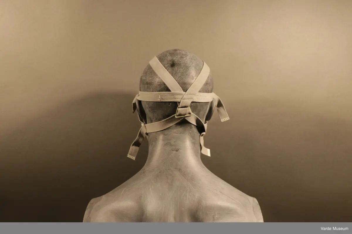 Sivilforsvaret gassmaske komplett med gass- og støvfilter. Masken er en ansiktsmaske med et stor synsfelt. Masken har seks festereimer og et samle-punkt .Gassmasken har to rektangulær festepunkt til gass og støvfilteret patroner.