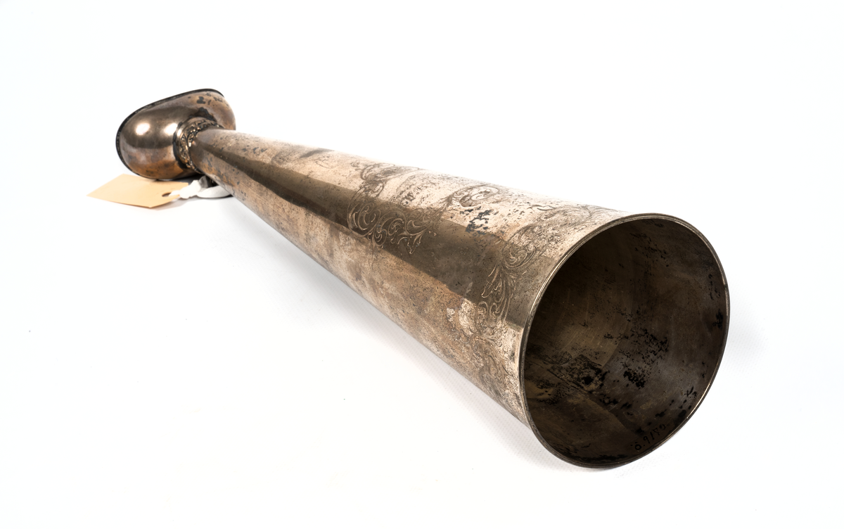 Ropare av silver. Munstycke med ring och dekor, vid mynningen gravyrslinga samt å mitten cartouch med texte: "Till premier Leutenant CWBJ. Forsell den 1 mars 1857." Silverstämpel: GM F tre kronor 8 C5 (Stockholm).