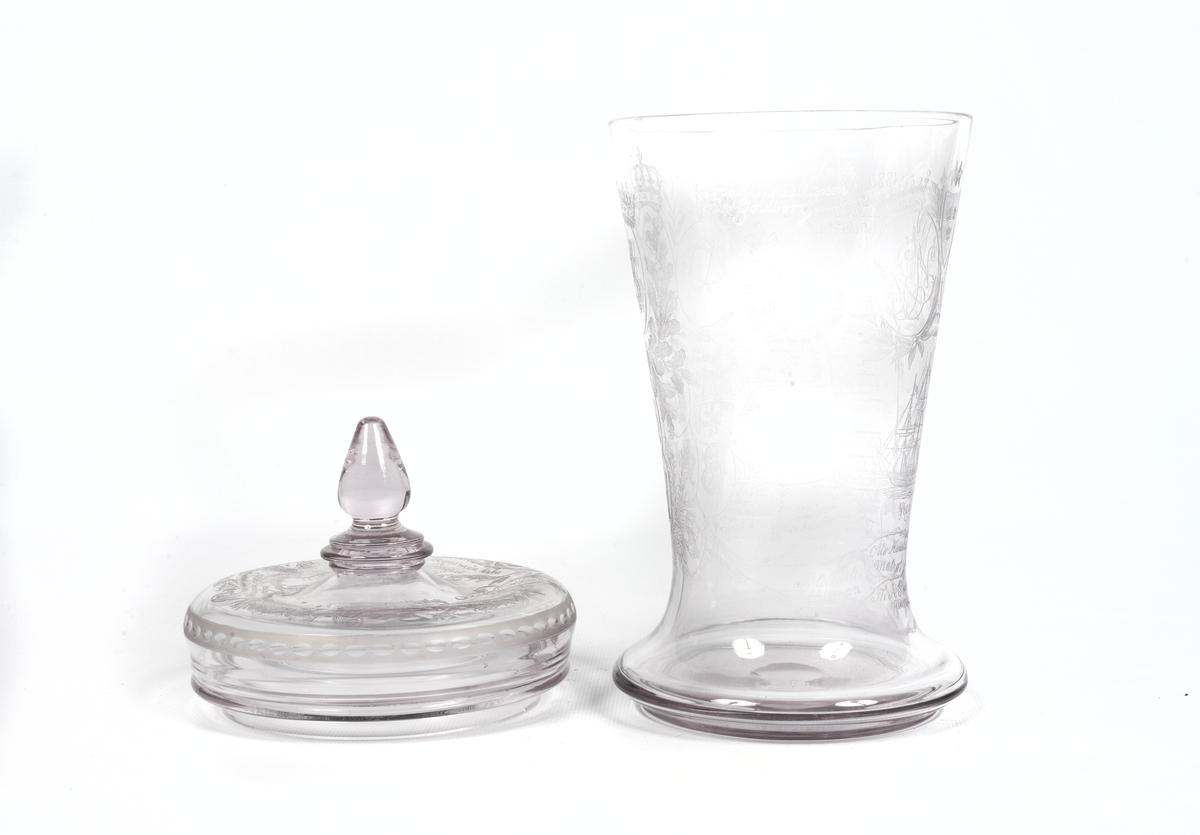 Minnespokal över Vegaexpeditionen av etsat och slipat glas. Dekorerad med Vegas bild, bladrankor, isberg och norrsken samt med donatorers och alla deltagares namn. Lock av etsat glas med liknande dekorering och text.