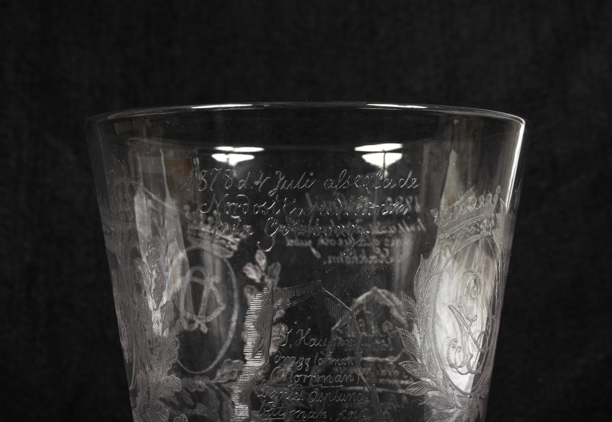 Minnespokal över Vegaexpeditionen av etsat och slipat glas. Dekorerad med Vegas bild, bladrankor, isberg och norrsken samt med donatorers och alla deltagares namn. Lock av etsat glas med liknande dekorering och text.