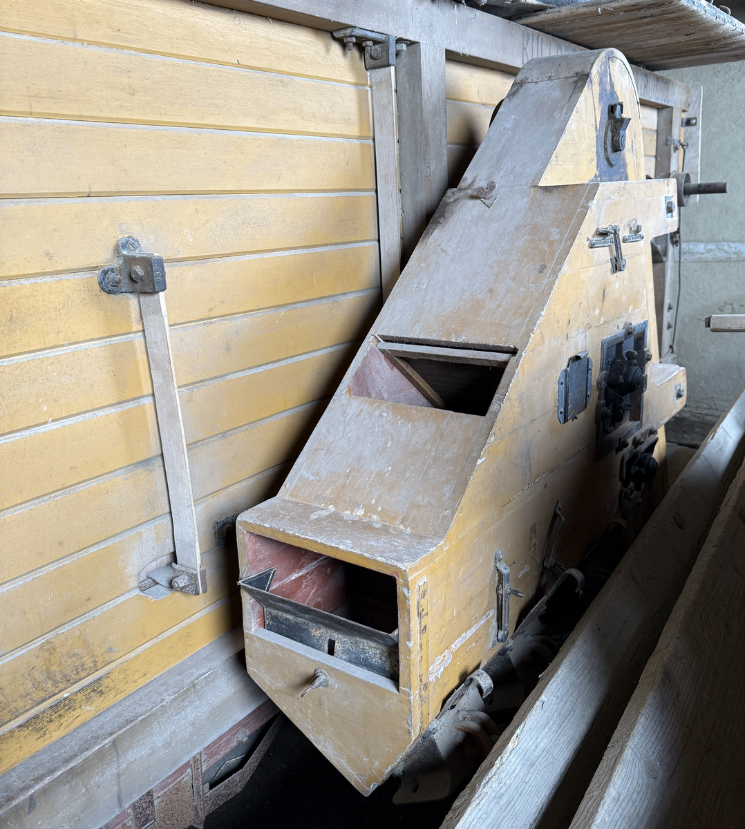 Tröskverk, fabriksgjort av AB Thermaeius & Sons, Hallsberg. Tillverkningsnummer 13 780. Avsett för drift med elmotor, tändkulemotor eller dragare, med remtransmission. Försålt av Generalförsäljare Kullberg & Co A.B. Katrineholm.
Verket består av en stor låda, byggd av trä och målad med gul färg. Det står på fyra hjul av gjutjärn. Inuti lådan finns ett maskineri av järn. Användandet tillgår så, att den torkade säden lastas in av en person i ena änden av lådan. Personen står på ett nerfällt flak och har ett matarbord till öppningen framför sig. Till vänster finns ett avtagbart bord, där kärven kan knytas upp. Kärven kommer först till en trumma av järn, där axen slås sönder. Trumman roterar med 950 v/min, enligt målad angivelse på utsidan. Där anges också rotationsriktningen. Även halmen trasas upp. Nertill i lådan finns en fläkt, som blåser undan bosset. De tunga sädeskornen faller ner i botten till en ränna, som leder till elevatorn. I denna, ett litet paternosterverk, lyfts säden upp för att sedan kunna falla ner i tre luckförsedda säckhållare. Halmen passerar ett skakverk och kommer ut i andra änden. 
Tranmissionsremmarna är av gummerad väv. Det går en rem från motorn till trummans axel. Dessutom går två drivremmar därifrån till skakverket, som har två funktioner: en för upp- och nergående rörelse, en för framåt-bakåtgående rörelse. På andra sidan finns drivremmar till fläkten och till elevatorn. Transmissionen skyddas av två enkla trägrindar. Utdraget mäter verket ungefär 5 580 mm. Största bredd med alla utbyggnader är 1 460 mm.
Stiften i trumman är sekundärt utbytta mot järnstift.
Under 1922 levererades 14 000 verk av denna typ, enkelrensande, transportabla och försedda med hjul. 

Funktion: Maskin som slår loss sädeskornen ur axen