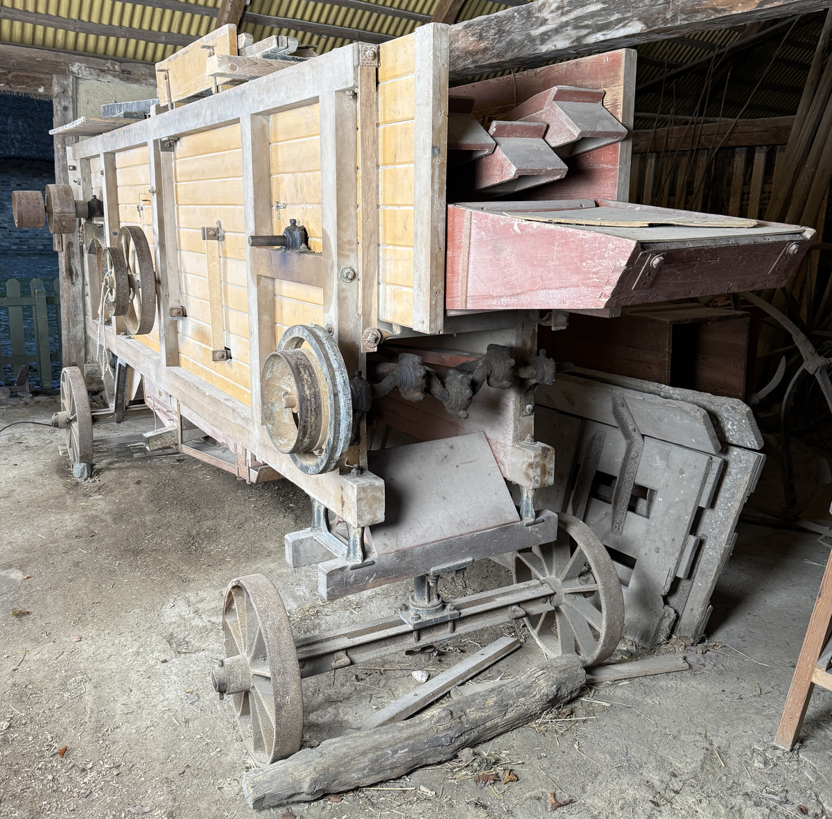 Tröskverk, fabriksgjort av AB Thermaeius & Sons, Hallsberg. Tillverkningsnummer 13 780. Avsett för drift med elmotor, tändkulemotor eller dragare, med remtransmission. Försålt av Generalförsäljare Kullberg & Co A.B. Katrineholm.
Verket består av en stor låda, byggd av trä och målad med gul färg. Det står på fyra hjul av gjutjärn. Inuti lådan finns ett maskineri av järn. Användandet tillgår så, att den torkade säden lastas in av en person i ena änden av lådan. Personen står på ett nerfällt flak och har ett matarbord till öppningen framför sig. Till vänster finns ett avtagbart bord, där kärven kan knytas upp. Kärven kommer först till en trumma av järn, där axen slås sönder. Trumman roterar med 950 v/min, enligt målad angivelse på utsidan. Där anges också rotationsriktningen. Även halmen trasas upp. Nertill i lådan finns en fläkt, som blåser undan bosset. De tunga sädeskornen faller ner i botten till en ränna, som leder till elevatorn. I denna, ett litet paternosterverk, lyfts säden upp för att sedan kunna falla ner i tre luckförsedda säckhållare. Halmen passerar ett skakverk och kommer ut i andra änden. 
Tranmissionsremmarna är av gummerad väv. Det går en rem från motorn till trummans axel. Dessutom går två drivremmar därifrån till skakverket, som har två funktioner: en för upp- och nergående rörelse, en för framåt-bakåtgående rörelse. På andra sidan finns drivremmar till fläkten och till elevatorn. Transmissionen skyddas av två enkla trägrindar. Utdraget mäter verket ungefär 5 580 mm. Största bredd med alla utbyggnader är 1 460 mm.
Stiften i trumman är sekundärt utbytta mot järnstift.
Under 1922 levererades 14 000 verk av denna typ, enkelrensande, transportabla och försedda med hjul. 

Funktion: Maskin som slår loss sädeskornen ur axen
