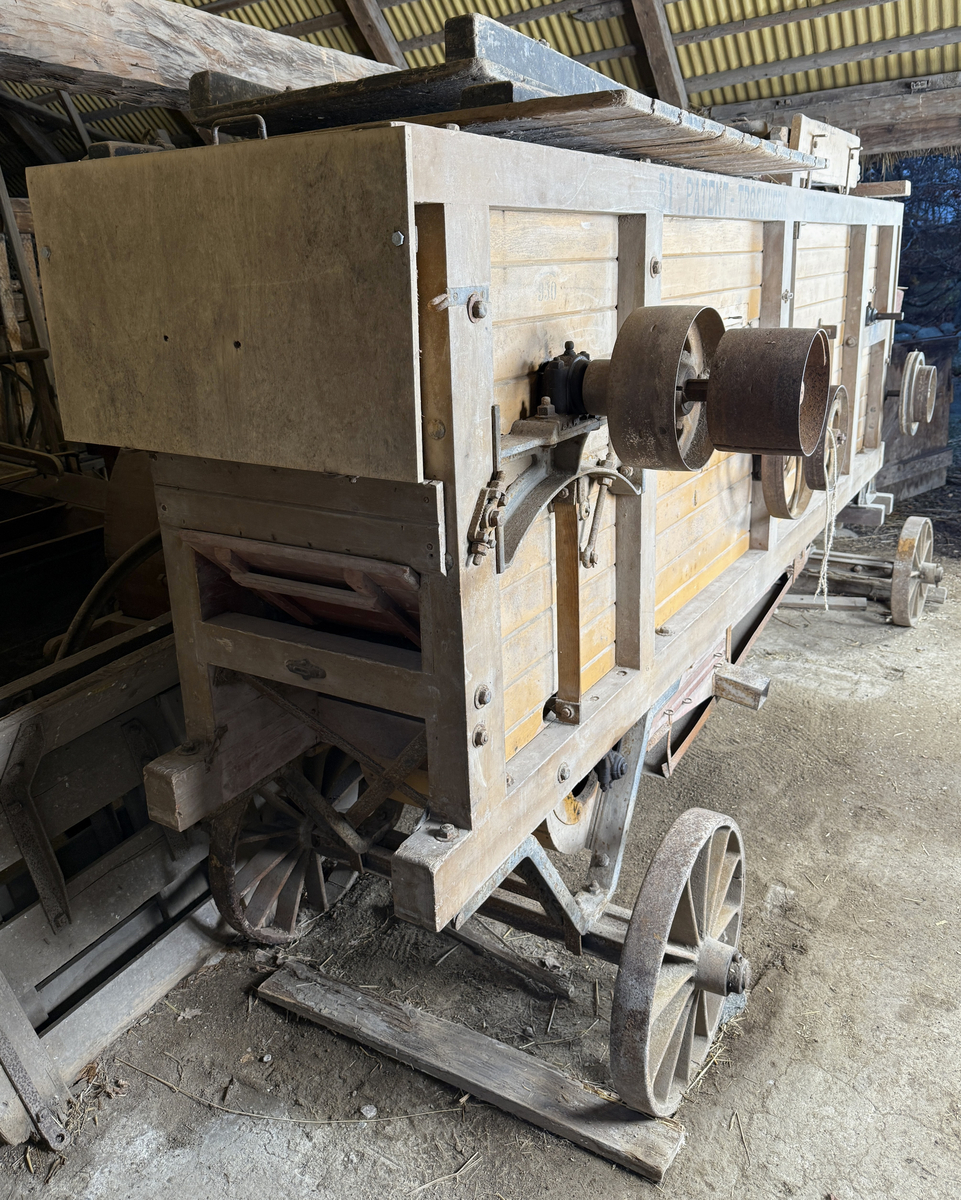 Tröskverk, fabriksgjort av AB Thermaeius & Sons, Hallsberg. Tillverkningsnummer 13 780. Avsett för drift med elmotor, tändkulemotor eller dragare, med remtransmission. Försålt av Generalförsäljare Kullberg & Co A.B. Katrineholm.
Verket består av en stor låda, byggd av trä och målad med gul färg. Det står på fyra hjul av gjutjärn. Inuti lådan finns ett maskineri av järn. Användandet tillgår så, att den torkade säden lastas in av en person i ena änden av lådan. Personen står på ett nerfällt flak och har ett matarbord till öppningen framför sig. Till vänster finns ett avtagbart bord, där kärven kan knytas upp. Kärven kommer först till en trumma av järn, där axen slås sönder. Trumman roterar med 950 v/min, enligt målad angivelse på utsidan. Där anges också rotationsriktningen. Även halmen trasas upp. Nertill i lådan finns en fläkt, som blåser undan bosset. De tunga sädeskornen faller ner i botten till en ränna, som leder till elevatorn. I denna, ett litet paternosterverk, lyfts säden upp för att sedan kunna falla ner i tre luckförsedda säckhållare. Halmen passerar ett skakverk och kommer ut i andra änden. 
Tranmissionsremmarna är av gummerad väv. Det går en rem från motorn till trummans axel. Dessutom går två drivremmar därifrån till skakverket, som har två funktioner: en för upp- och nergående rörelse, en för framåt-bakåtgående rörelse. På andra sidan finns drivremmar till fläkten och till elevatorn. Transmissionen skyddas av två enkla trägrindar. Utdraget mäter verket ungefär 5 580 mm. Största bredd med alla utbyggnader är 1 460 mm.
Stiften i trumman är sekundärt utbytta mot järnstift.
Under 1922 levererades 14 000 verk av denna typ, enkelrensande, transportabla och försedda med hjul. 

Funktion: Maskin som slår loss sädeskornen ur axen