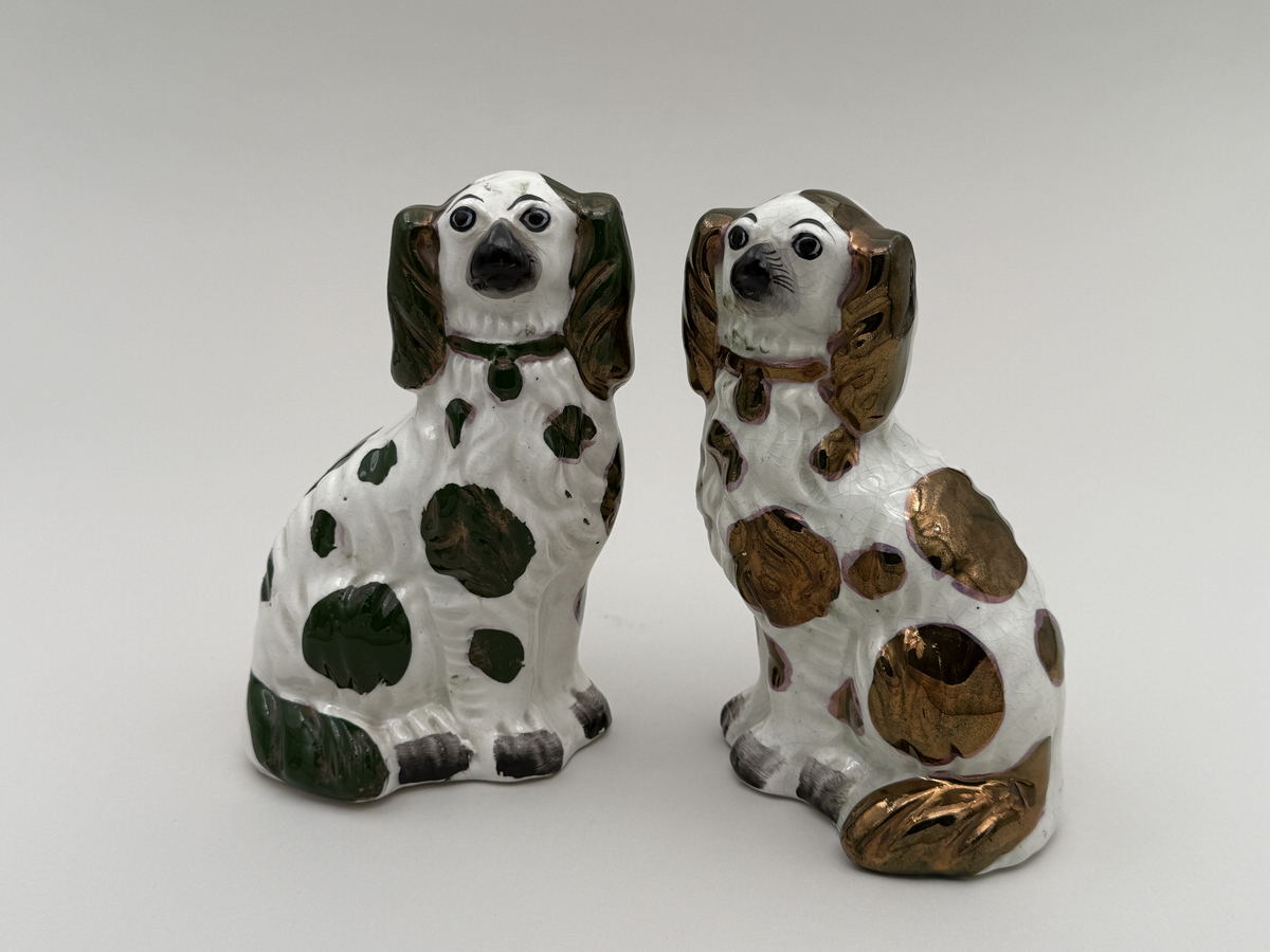 Figuriner av porslin i form av sittande hundar, glaserade, med överglasymålad dekor och förgyllning.  