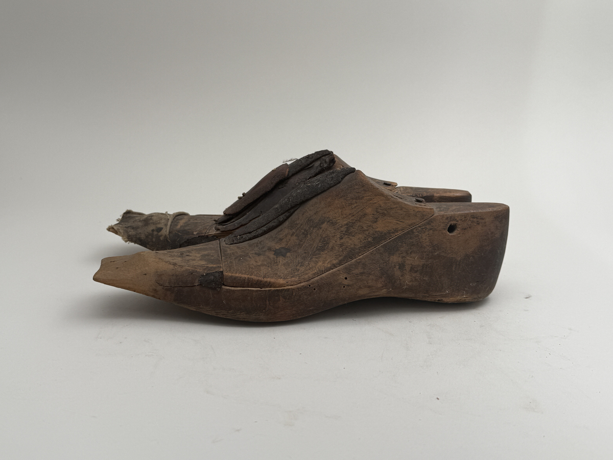 Skoläst för herrskor.
Gjorda i björkträ med läderbitar fastpliggade på vristdelen. Höger tåhäll klädd med lärft. 