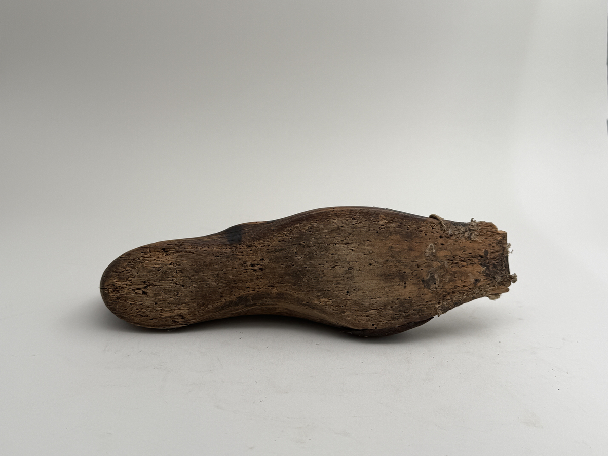 Skoläst för herrskor. Högerfot.
Gjord i björkträ med läderbitar fastpliggade på vristdelen. Tåhällen klädd med lärft. 
 