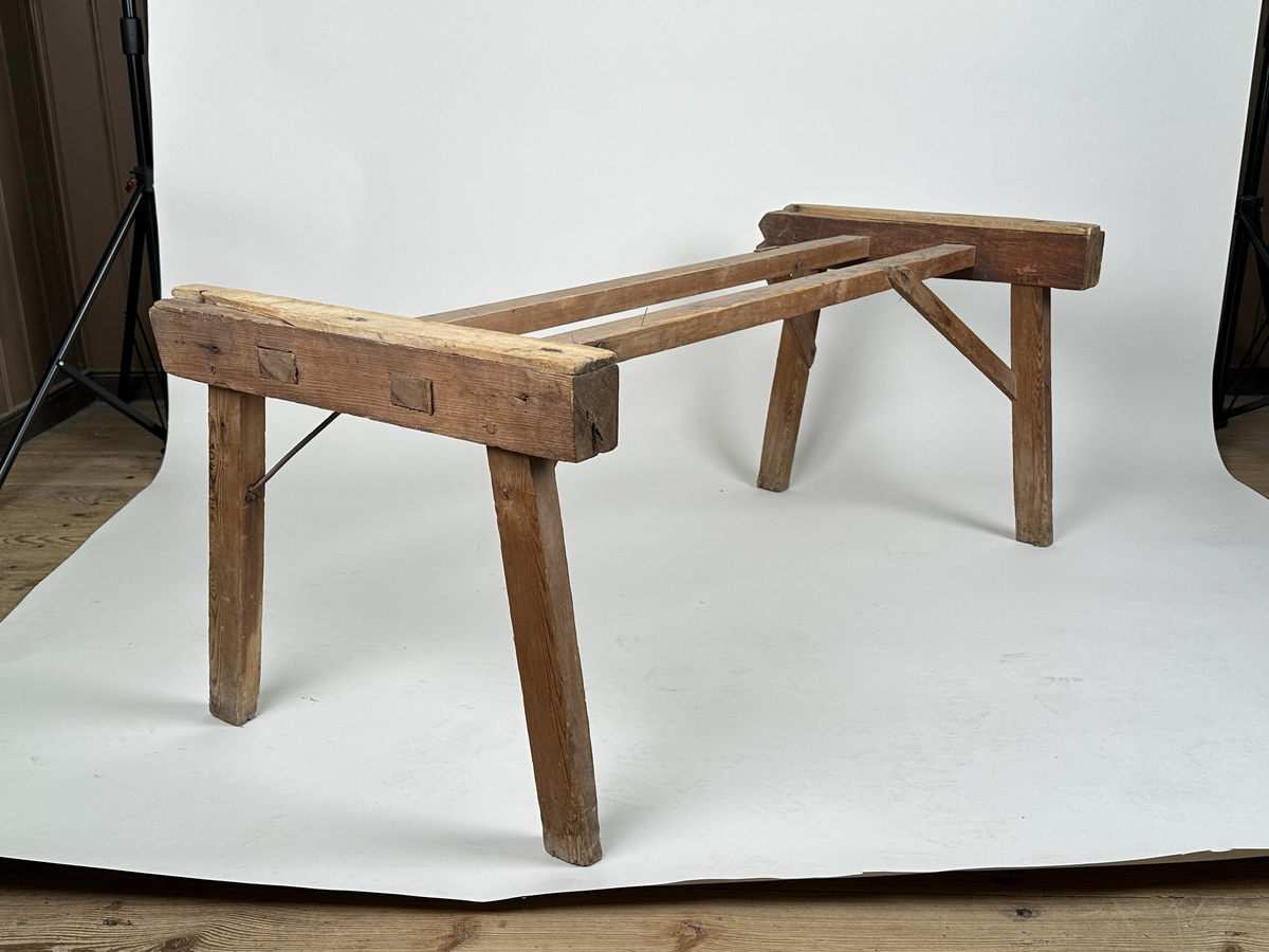 Ställning till baktråg. Av furu med två snedsträvor av rundjärn samt två i trä. 