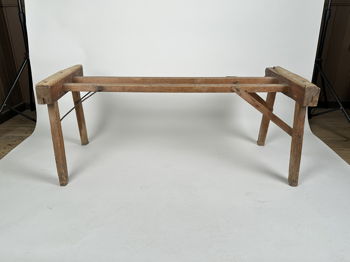 Ställning till baktråg. Av furu med två snedsträvor av rundjärn samt två i trä. 