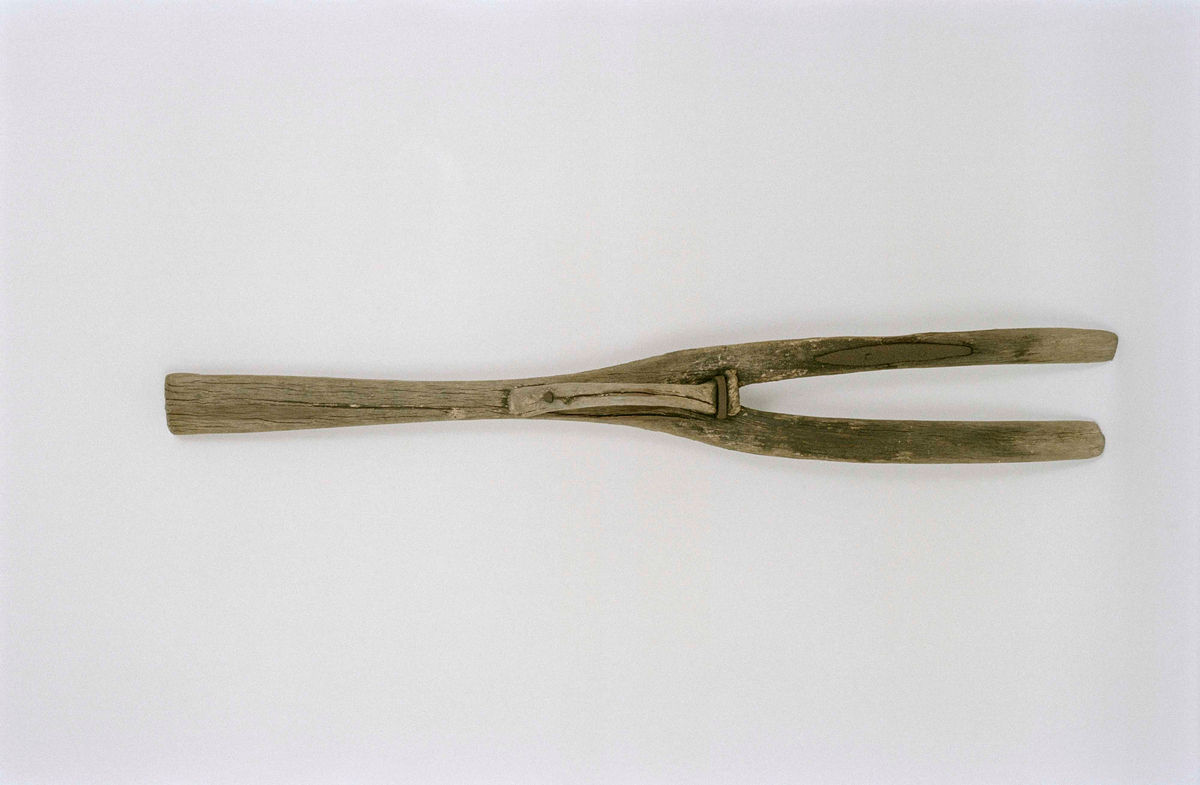 Dynggrep av björk med två långa platta klor, skaftet med utskuret handvalk. Mitt på ett handtag av självvuxen trägren fastsatt med spik och märla. På ena klon en spricka lagad med avlångt järnbeslag.