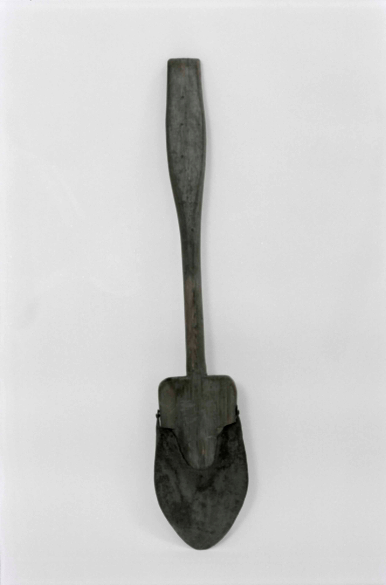 Spade, av barrträ med rundat järnskott blad, skaftet med handvalk, inskuret "A" samt bomärke.