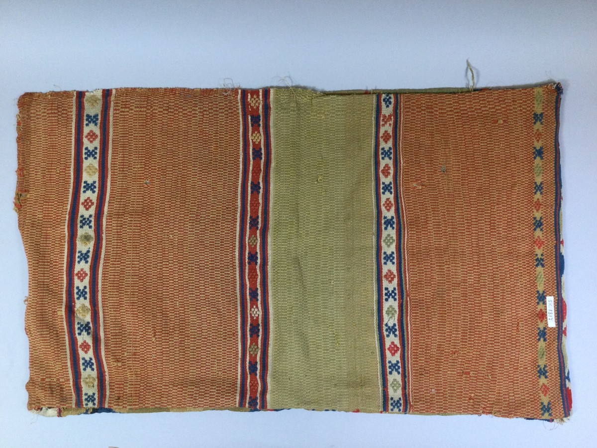 Åkdyna.
Röllakan, ylle på linnevarp, vävt i ett stycke med randig baksida. Trasigt.

Funktion: Komfort och dekoration vid resa
Mycket slitet.