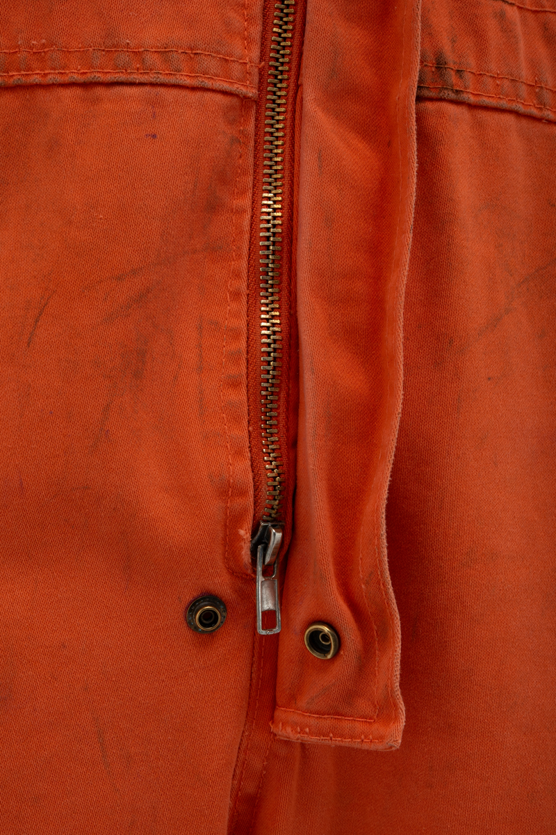 Kjeledress i størrelse 60 med Archer sin logo. Kjeledressen er utstyrt med flere utvendige lommer og reflekser. Innvendig i nakke er det festet en etikett med plattformnavn og QR-kode.