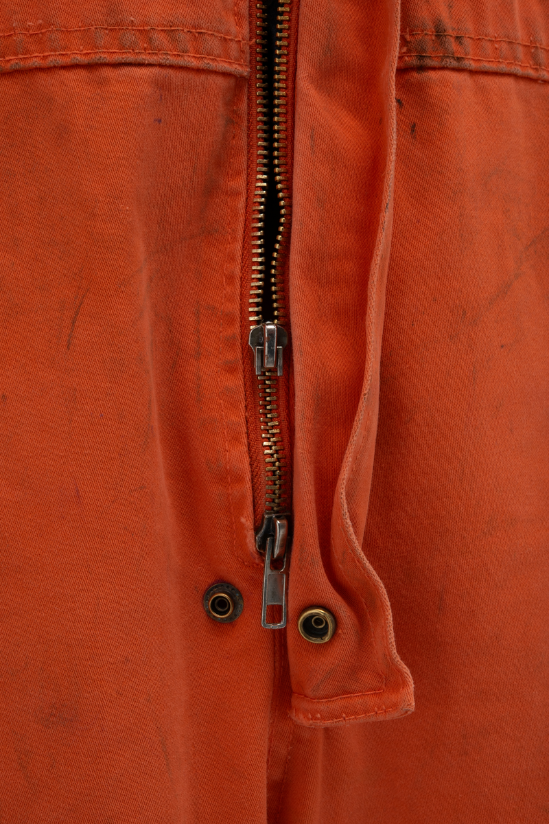 Kjeledress i størrelse 60 med Archer sin logo. Kjeledressen er utstyrt med flere utvendige lommer og reflekser. Innvendig i nakke er det festet en etikett med plattformnavn og QR-kode.