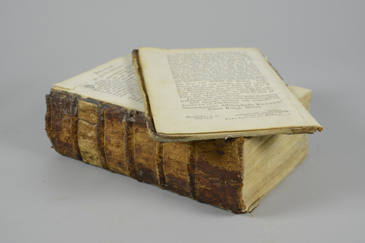 Bok, halvfranskt band, "Sammandrag af Swea rikes historia",upplaga 2, del 1, tryckt i Stockholm1784 av Anders J. Nordström.
Band med blindpressad och guldornerad rygg i fem upphöjda bind, titelfält med blindpressad titel (oläslig).