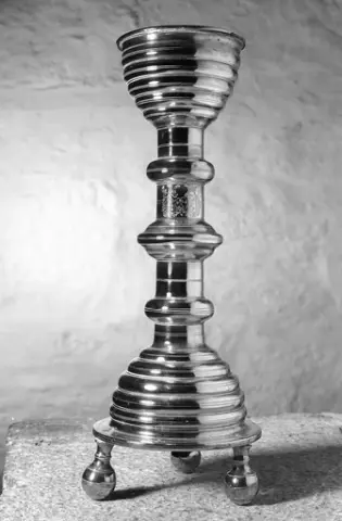 Ringsaker kirke, messing lysestake fra 1540-47, inngravert våpenskjold til familien Eiler Brockenhus og Kirsten Gyldenhorn,