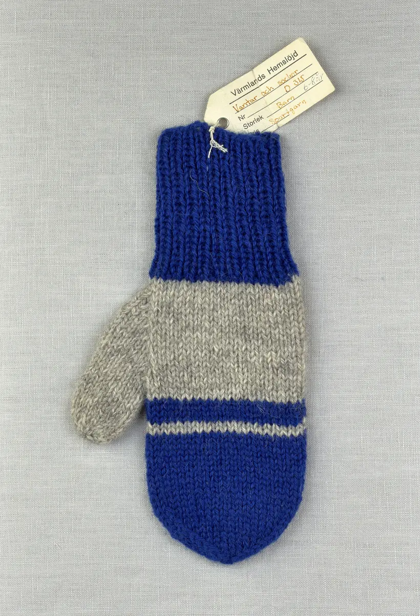 En stickad tumvante, med mudd i 1-1 resår (1 rät och 1 avig maska) och randig vante i slätstickning, av 3-trådigt Sportgarn i ull. Vanten är gjord med kiltumme i ena sidan och avslutas med bandhoptagning i toppen.
Gjord efter Bergå beskrivning D 315 från Bergå Färgeri & Ullspinneri, Stora Skedvi, Dalarna.