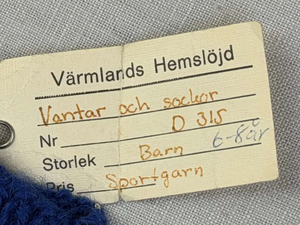 En stickad tumvante, med mudd i 1-1 resår (1 rät och 1 avig maska) och randig vante i slätstickning, av 3-trådigt Sportgarn i ull. Vanten är gjord med kiltumme i ena sidan och avslutas med bandhoptagning i toppen.
Gjord efter Bergå beskrivning D 315 från Bergå Färgeri & Ullspinneri, Stora Skedvi, Dalarna.
