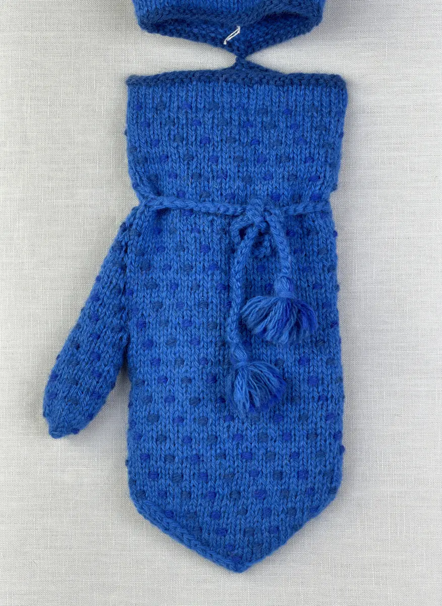 Ett par stickade herrvantar, i slätstickning med nockor på vantens insida, av 3-trådigt sportgarn i ull. Nockornas/knutarnas "baksida" bildar ett prickmönster på vantens utsida. 
Vanten har två garntofsar med virkad snodd, kiltumme i sidan och är avslutad med bandhoptagning i toppen.