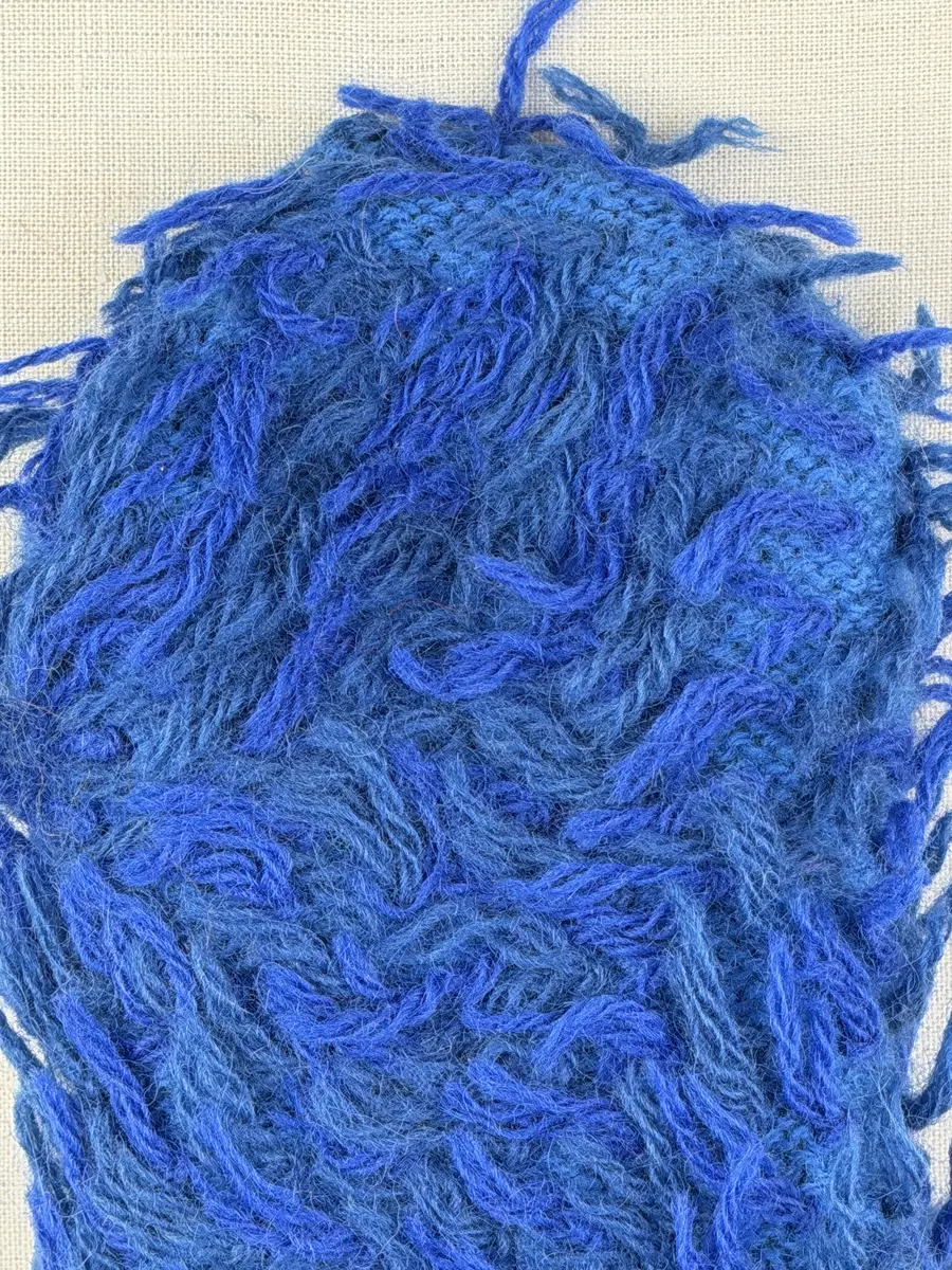 Ett par stickade herrvantar, i slätstickning med nockor på vantens insida, av 3-trådigt sportgarn i ull. Nockornas/knutarnas "baksida" bildar ett prickmönster på vantens utsida. 
Vanten har två garntofsar med virkad snodd, kiltumme i sidan och är avslutad med bandhoptagning i toppen.