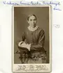 Porträtt sannolikt av bondhustrun Anna Greta Jacobsdotter, som från 1875 och tillsammans med maken Viktor Karlsson ägde och brukade en del i Bjärkeryd Södergård söder om Kisa. Bördig från Ulrika församling hade hon dessförinnan, 1867, gift sig med Viktor, som då var rättare på den större gården Kvarntorp väster om Kisa. Fotografiet kan antas tillkommit vid 1870-talets senare hälft.