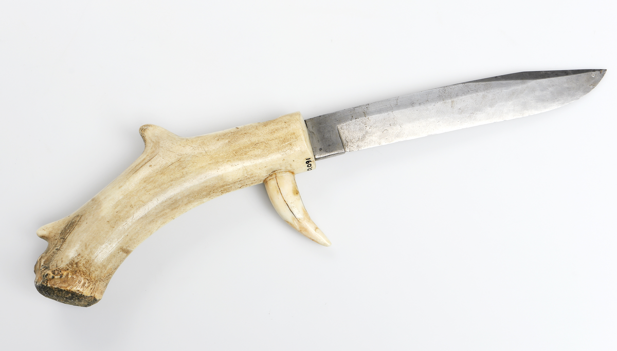 Jaktkniv med dubbelslipad klinga med bred rygg. Klingans spets är något nedböjd. Klingan är stämplad: Joh. Rab. Ups. Skaftet har två urborrningar längst fram vid klingans infästning. Där finns två böjda betar fästa med spetsarna vända framåt. De bildar en enkel parerstång. 
Har brukats som jaktkniv dvs vid styckning av viltet etc., för utdelande av det dödande sticket eller som en ren statussymbol.

Inskrivet i huvudkatalogen 1938.