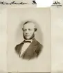 Anspråkslöst porträtt av Knut Arvid Kastman som ungefärligen kan dateras till tiden omkring 1875. Född i Västerlösa avlade han år 1862 både en teologisk- och folkskolelärarexamen i Uppsala. Därefter följde en karriär inom läraryrket vid folkskoleseminarierna i Linköping, Falun och Kalmar. Från 1877 istället kyrkoherde i Örberga, Nässja, Törnevalla och slutligen Kuddby. Från 1870 gift med Anna Emelinda Amalia Dorotea Sjögreen.