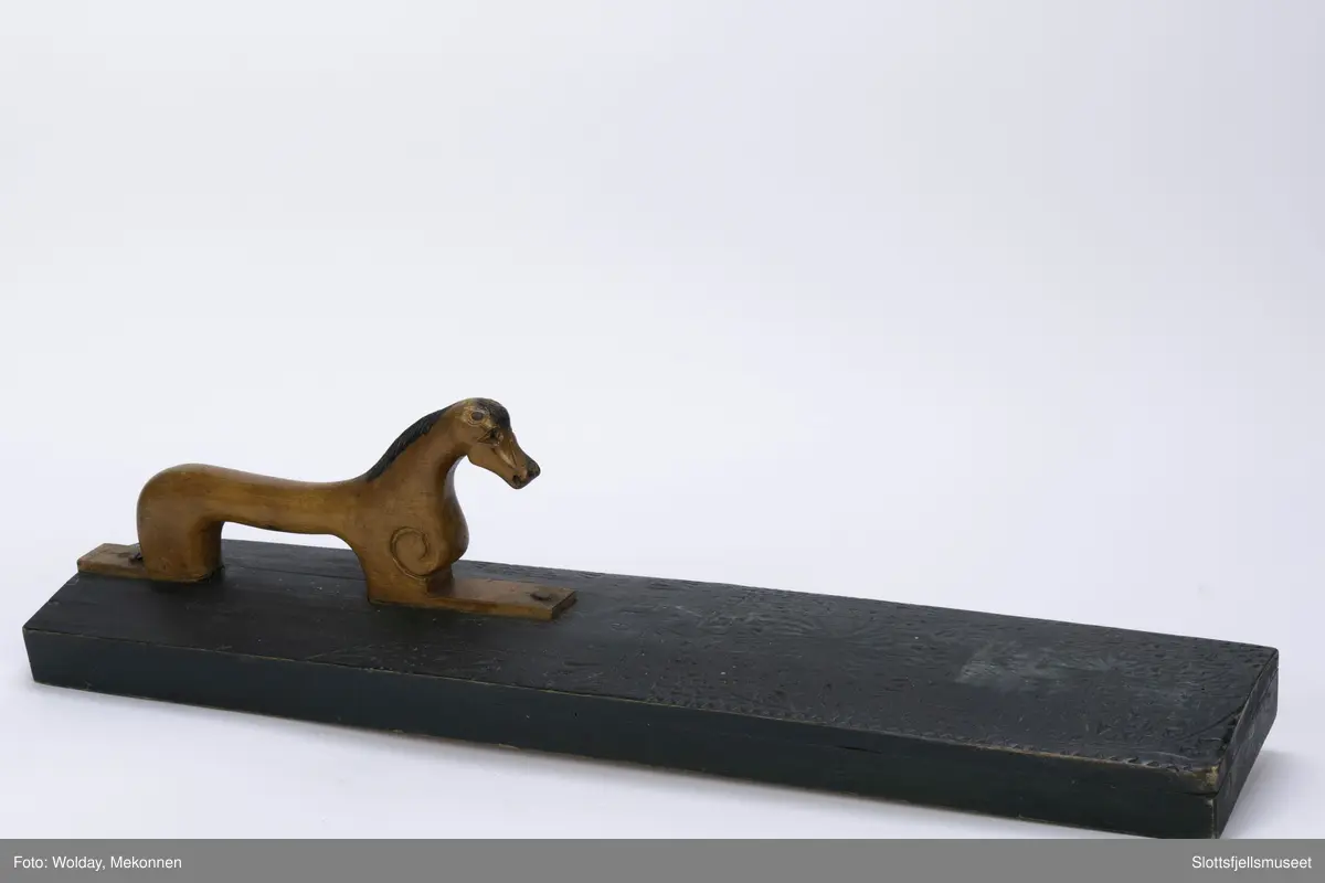 Hesteformet håndtak. Grunn karveskurd dekor. Mangletreet er sortmalt, håndtaket kun oljet.