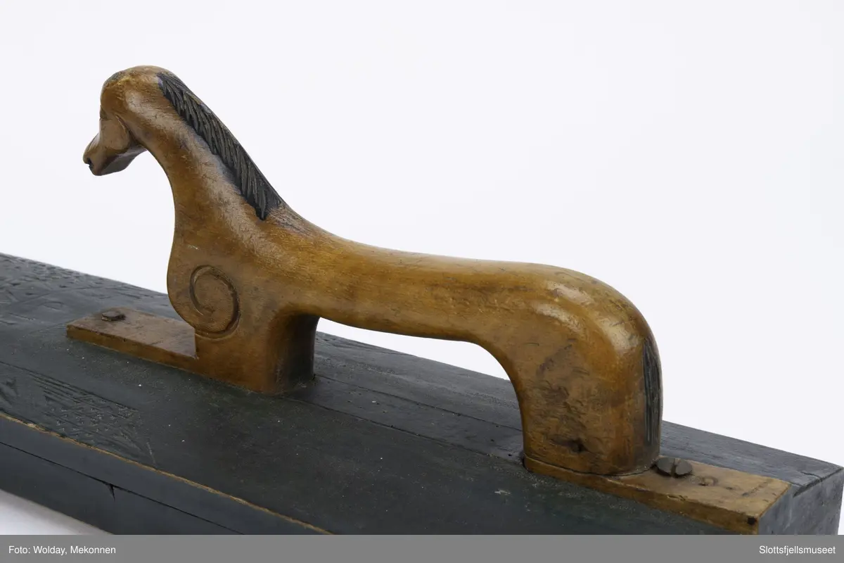 Hesteformet håndtak. Grunn karveskurd dekor. Mangletreet er sortmalt, håndtaket kun oljet.