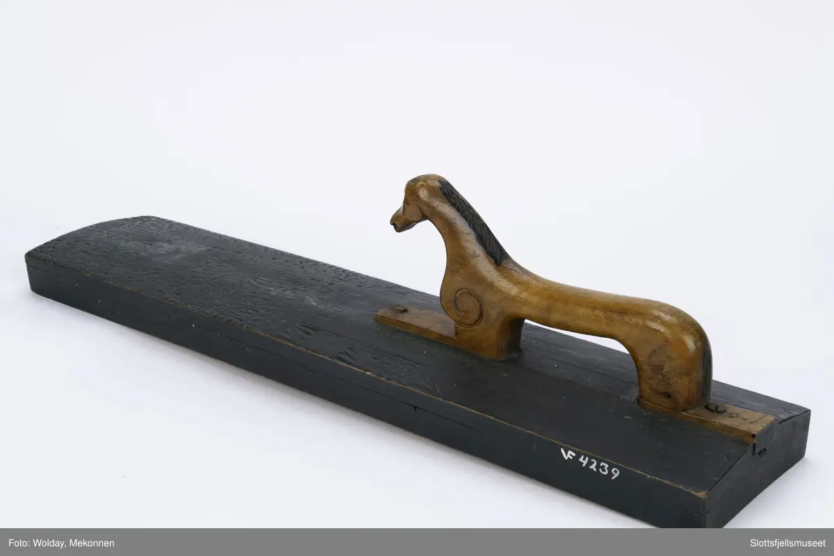 Hesteformet håndtak. Grunn karveskurd dekor. Mangletreet er sortmalt, håndtaket kun oljet.