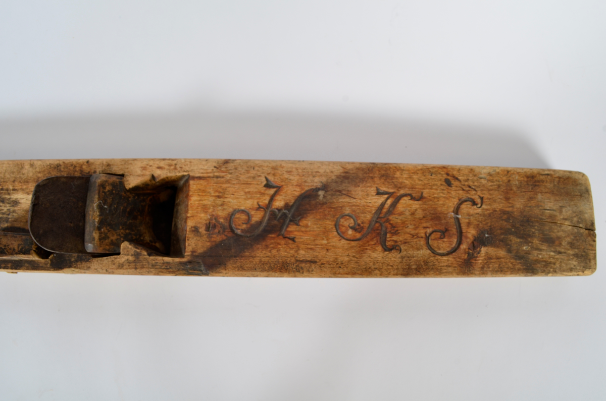 Sponhøvel i bjørk. Utskåren, lite utsprang nederst på bakre del. Nærmest rektangulært hull som smalner nedover med kniv og tretapp til festing, og rom til spon framom. Lite håndtak mot venstre side, lengre bak, festet med trenagle. Innskåret initialer og årstall.