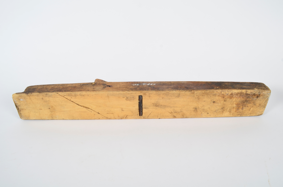 Sponhøvel i bjørk. Utskåren, lite utsprang nederst på bakre del. Nærmest rektangulært hull som smalner nedover med kniv og tretapp til festing, og rom til spon framom. Lite håndtak mot venstre side, lengre bak, festet med trenagle. Innskåret initialer og årstall.