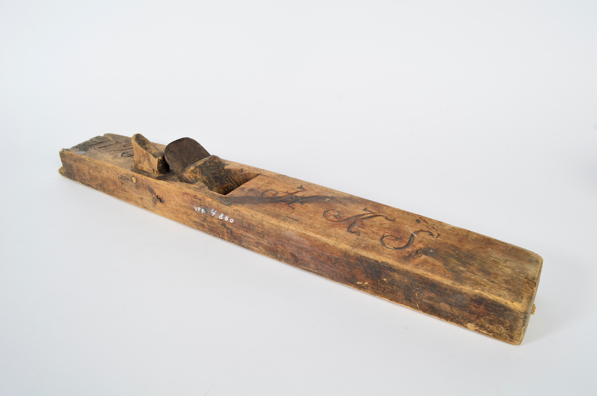 Sponhøvel i bjørk. Utskåren, lite utsprang nederst på bakre del. Nærmest rektangulært hull som smalner nedover med kniv og tretapp til festing, og rom til spon framom. Lite håndtak mot venstre side, lengre bak, festet med trenagle. Innskåret initialer og årstall.