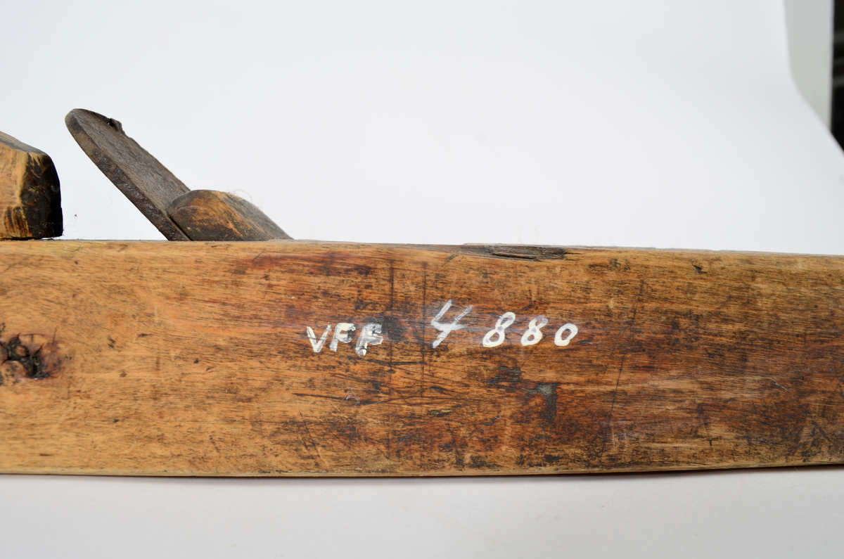 Sponhøvel i bjørk. Utskåren, lite utsprang nederst på bakre del. Nærmest rektangulært hull som smalner nedover med kniv og tretapp til festing, og rom til spon framom. Lite håndtak mot venstre side, lengre bak, festet med trenagle. Innskåret initialer og årstall.