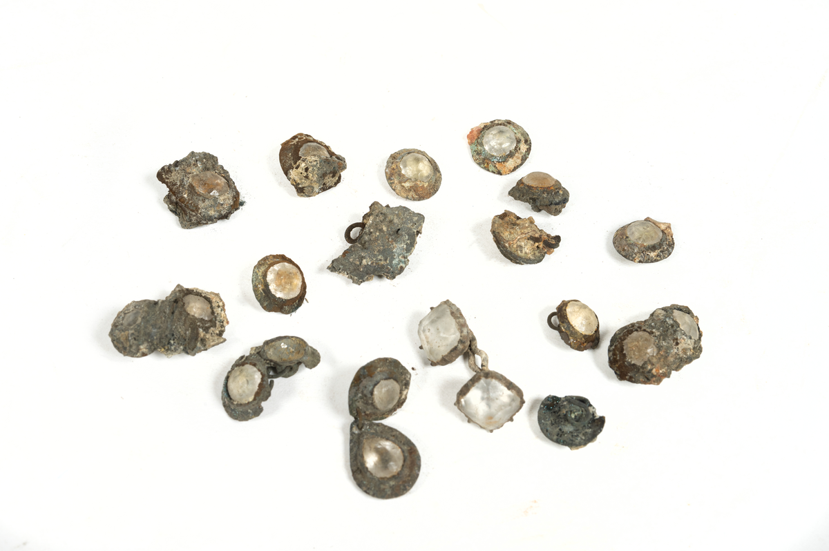 Smyckesstenar av glas. Både lösa och infattade i metall. Gröna och transperenta.