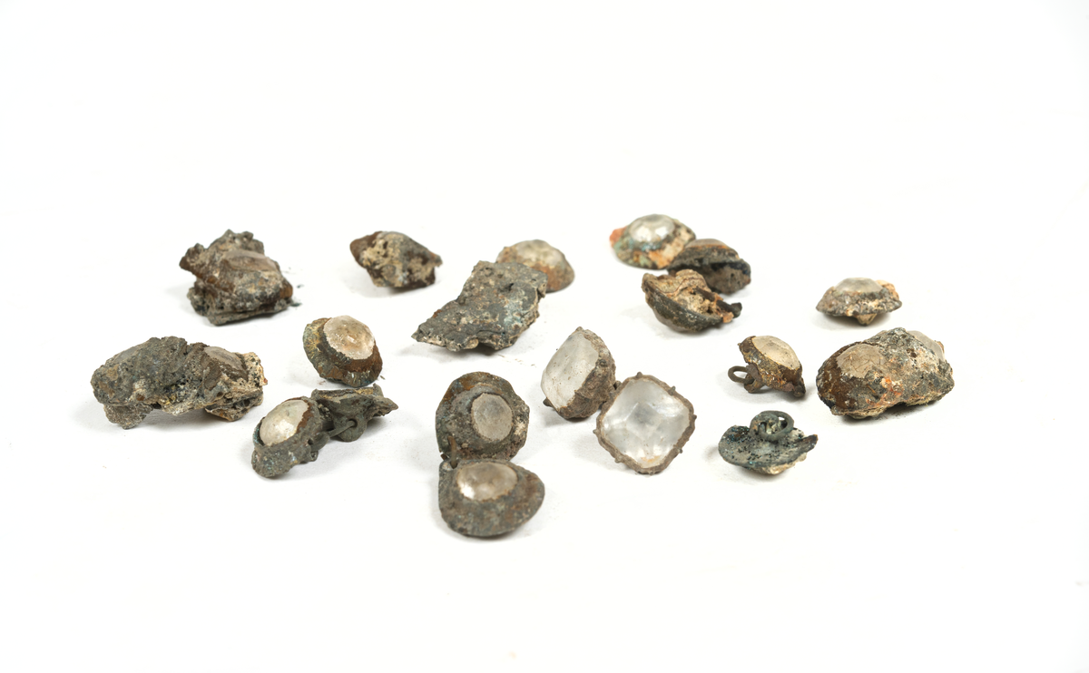 Smyckesstenar av glas. Både lösa och infattade i metall. Gröna och transperenta.