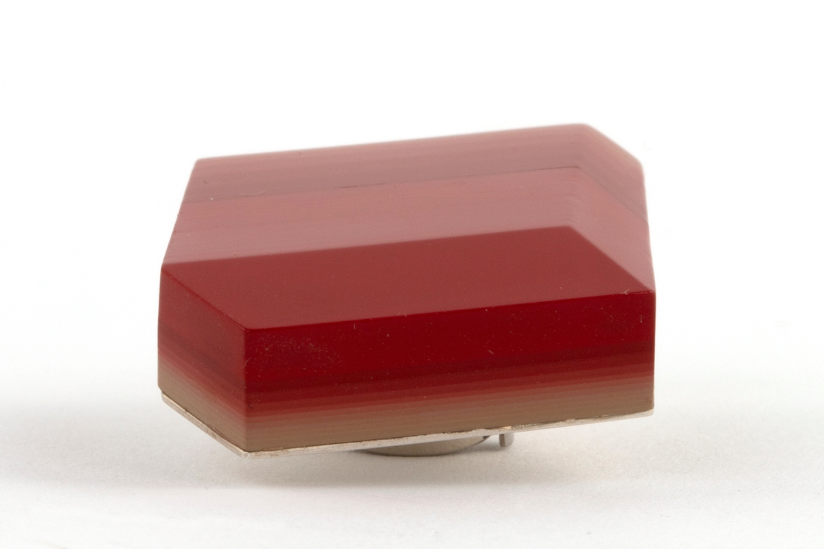 Brosje lagd av Urushi-lakk med teknikken cho-shitsu. 3 mm tykke lag lakt 100 ganger. Overgangen mellom lagene synes i fargene på lakken. Brosjen kan sies å være todelt. Nederste del kan sees som en base der fargene på lakklagene går fra lys gulbeige til mørk rød. Den øverste delen er monokrom rød. Brosjen har syv kanter og skaper en tredimensjonal effekt. Lakken er montert på en sølvplate med pin.