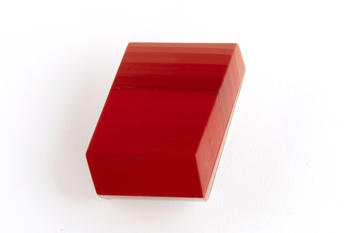 Brosje lagd av Urushi-lakk med teknikken cho-shitsu. 3 mm tykke lag lakt 100 ganger. Overgangen mellom lagene synes i fargene på lakken. Brosjen kan sies å være todelt. Nederste del kan sees som en base der fargene på lakklagene går fra lys gulbeige til mørk rød. Den øverste delen er monokrom rød. Brosjen har syv kanter og skaper en tredimensjonal effekt. Lakken er montert på en sølvplate med pin.