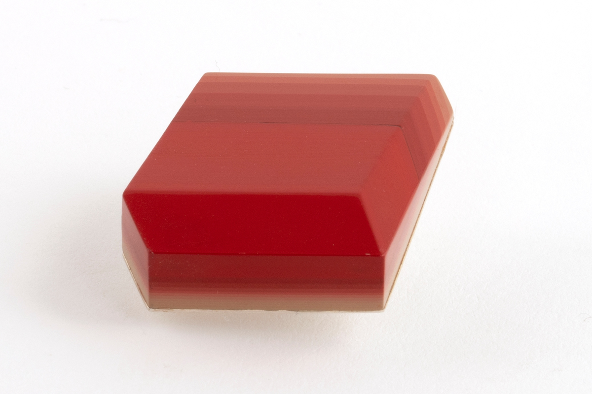 Brosje lagd av Urushi-lakk med teknikken cho-shitsu. 3 mm tykke lag lakt 100 ganger. Overgangen mellom lagene synes i fargene på lakken. Brosjen kan sies å være todelt. Nederste del kan sees som en base der fargene på lakklagene går fra lys gulbeige til mørk rød. Den øverste delen er monokrom rød. Brosjen har syv kanter og skaper en tredimensjonal effekt. Lakken er montert på en sølvplate med pin.