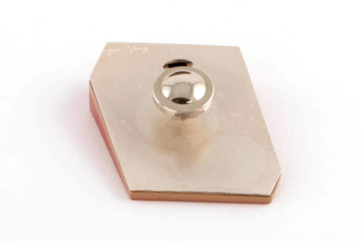 Brosje lagd av Urushi-lakk med teknikken cho-shitsu. 3 mm tykke lag lakt 100 ganger. Overgangen mellom lagene synes i fargene på lakken. Brosjen kan sies å være todelt. Nederste del kan sees som en base der fargene på lakklagene går fra lys gulbeige til mørk rød. Den øverste delen er monokrom rød. Brosjen har syv kanter og skaper en tredimensjonal effekt. Lakken er montert på en sølvplate med pin.