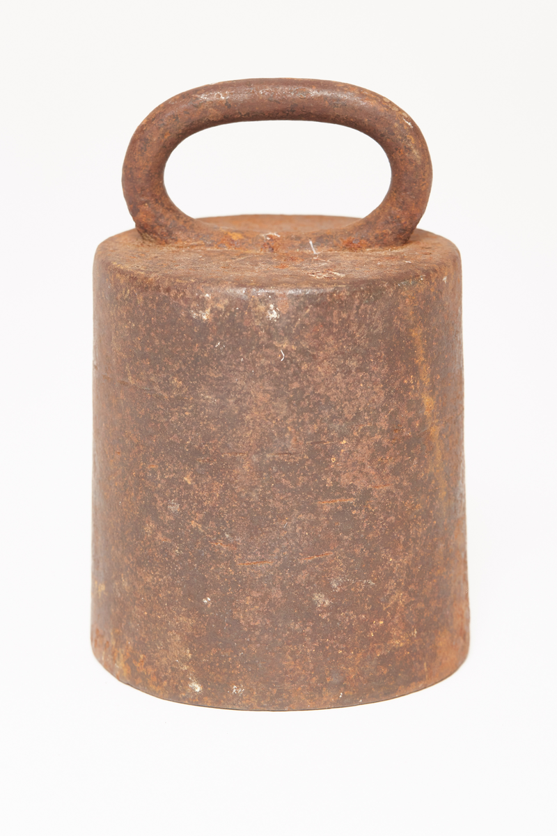 Et svart vektlodd, rundt, videst nederst, håndtak på toppen, tekst på loddet 8 Lb, gotisk skrift