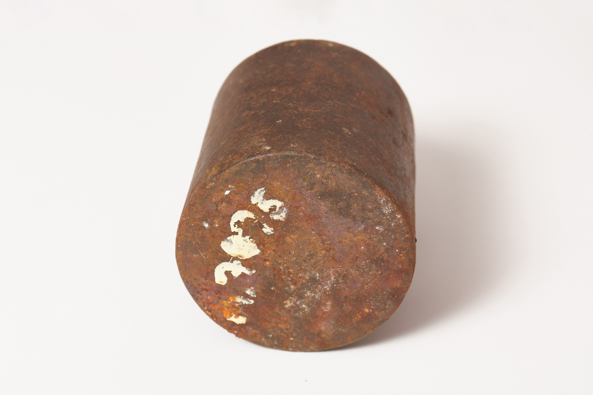 Et svart vektlodd, rundt, videst nederst, håndtak på toppen, tekst på loddet 8 Lb, gotisk skrift