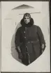 Porträtten visar flygaren Acke i flygardräckt bestående av en tjock kappa, vantar, huvudbonad i läder och glasögon.
