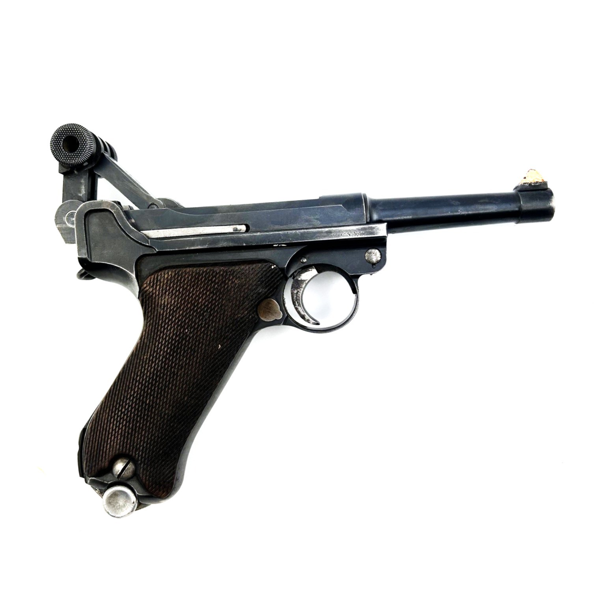 Pistol av modell Luger P08 Parabellum, automatpistol. Smal pipa samt grepp klätt av trä med nätmönster, så kallad nätskärning. Stommens sida samt pipans underdel stämplad med krönt "N". Stommens sida märkt "S/42" samt en mängd nummer 65, 43 samt 9570. Greppets baksida märkt: "M" ankare samt "N.122". Siktet är rödmålat som vittnar om vapnets användning inom skjutsport. Lackrest på stommens ena sida, troligen från ett tidigare fäst märke. Magasinet märkt: 9503, ett u i skrivstil samt stämpel av tyska örnen och nummer 63. Det finns en spricka i manteln.