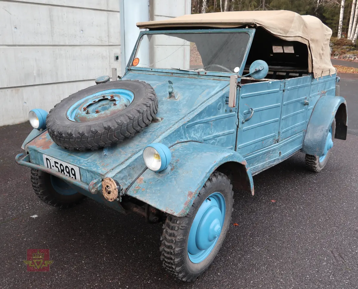 Volkswagen Typ 82 Kübelwagen. Åpen (med kalesje). Blå utvendig og hvit innvendig. Opprinnelig har hele bilen vært sandfarget. Man kan også se rester av grønn farge under det blå. Svart motorrom. Bilen har fire hjul og er toakslet med trekk på bakre. Bensindrevet firesylindret firetakts motor med et sylindervolum på 1192 cm3 og en effekt på 31 hk - 23 kW. Motoren har forgasser, er luftavkjølt, og sitter bak på bilen. 4-trinns manuell girkasse med spak i gulvet. Antall sitteplasser var tre ettersom dette opprinnelig er en radiobil, men nå har bilen sofa bak som tilsier fire sitteplasser totalt. Original dekkdimensjon rundt om skal være 5.00 x 16. Bilen har innvendig gulv av tre, dette er ikke det originale. Frontruta er sprekt. Kilometerstand på instrumentet viser 28084 km.