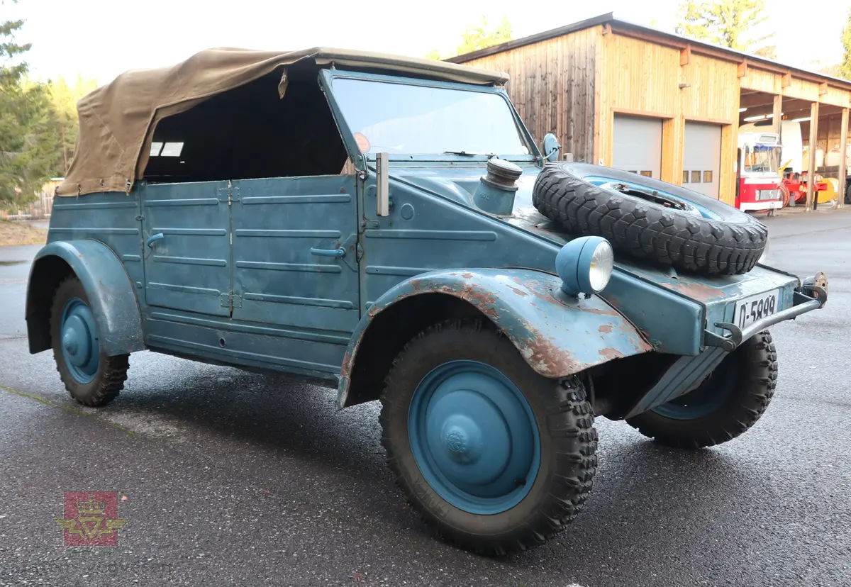Volkswagen Typ 82 Kübelwagen. Åpen (med kalesje). Blå utvendig og hvit innvendig. Opprinnelig har hele bilen vært sandfarget. Man kan også se rester av grønn farge under det blå. Svart motorrom. Bilen har fire hjul og er toakslet med trekk på bakre. Bensindrevet firesylindret firetakts motor med et sylindervolum på 1192 cm3 og en effekt på 31 hk - 23 kW. Motoren har forgasser, er luftavkjølt, og sitter bak på bilen. 4-trinns manuell girkasse med spak i gulvet. Antall sitteplasser var tre ettersom dette opprinnelig er en radiobil, men nå har bilen sofa bak som tilsier fire sitteplasser totalt. Original dekkdimensjon rundt om skal være 5.00 x 16. Bilen har innvendig gulv av tre, dette er ikke det originale. Frontruta er sprekt. Kilometerstand på instrumentet viser 28084 km.
