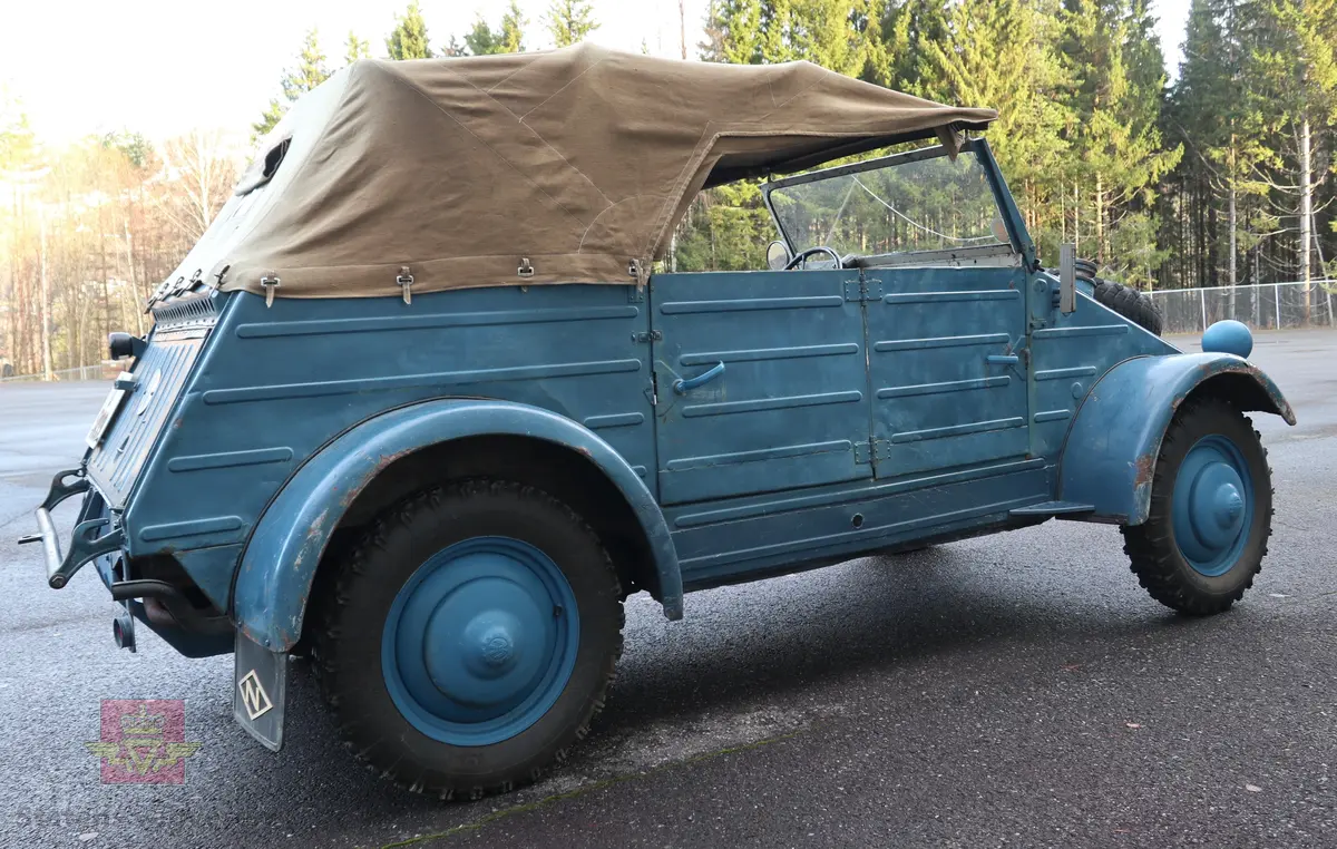 Volkswagen Typ 82 Kübelwagen. Åpen (med kalesje). Blå utvendig og hvit innvendig. Opprinnelig har hele bilen vært sandfarget. Man kan også se rester av grønn farge under det blå. Svart motorrom. Bilen har fire hjul og er toakslet med trekk på bakre. Bensindrevet firesylindret firetakts motor med et sylindervolum på 1192 cm3 og en effekt på 31 hk - 23 kW. Motoren har forgasser, er luftavkjølt, og sitter bak på bilen. 4-trinns manuell girkasse med spak i gulvet. Antall sitteplasser var tre ettersom dette opprinnelig er en radiobil, men nå har bilen sofa bak som tilsier fire sitteplasser totalt. Original dekkdimensjon rundt om skal være 5.00 x 16. Bilen har innvendig gulv av tre, dette er ikke det originale. Frontruta er sprekt. Kilometerstand på instrumentet viser 28084 km.