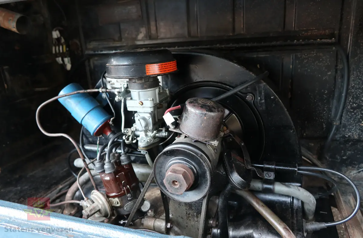 Volkswagen Typ 82 Kübelwagen. Åpen (med kalesje). Blå utvendig og hvit innvendig. Opprinnelig har hele bilen vært sandfarget. Man kan også se rester av grønn farge under det blå. Svart motorrom. Bilen har fire hjul og er toakslet med trekk på bakre. Bensindrevet firesylindret firetakts motor med et sylindervolum på 1192 cm3 og en effekt på 31 hk - 23 kW. Motoren har forgasser, er luftavkjølt, og sitter bak på bilen. 4-trinns manuell girkasse med spak i gulvet. Antall sitteplasser var tre ettersom dette opprinnelig er en radiobil, men nå har bilen sofa bak som tilsier fire sitteplasser totalt. Original dekkdimensjon rundt om skal være 5.00 x 16. Bilen har innvendig gulv av tre, dette er ikke det originale. Frontruta er sprekt. Kilometerstand på instrumentet viser 28084 km.